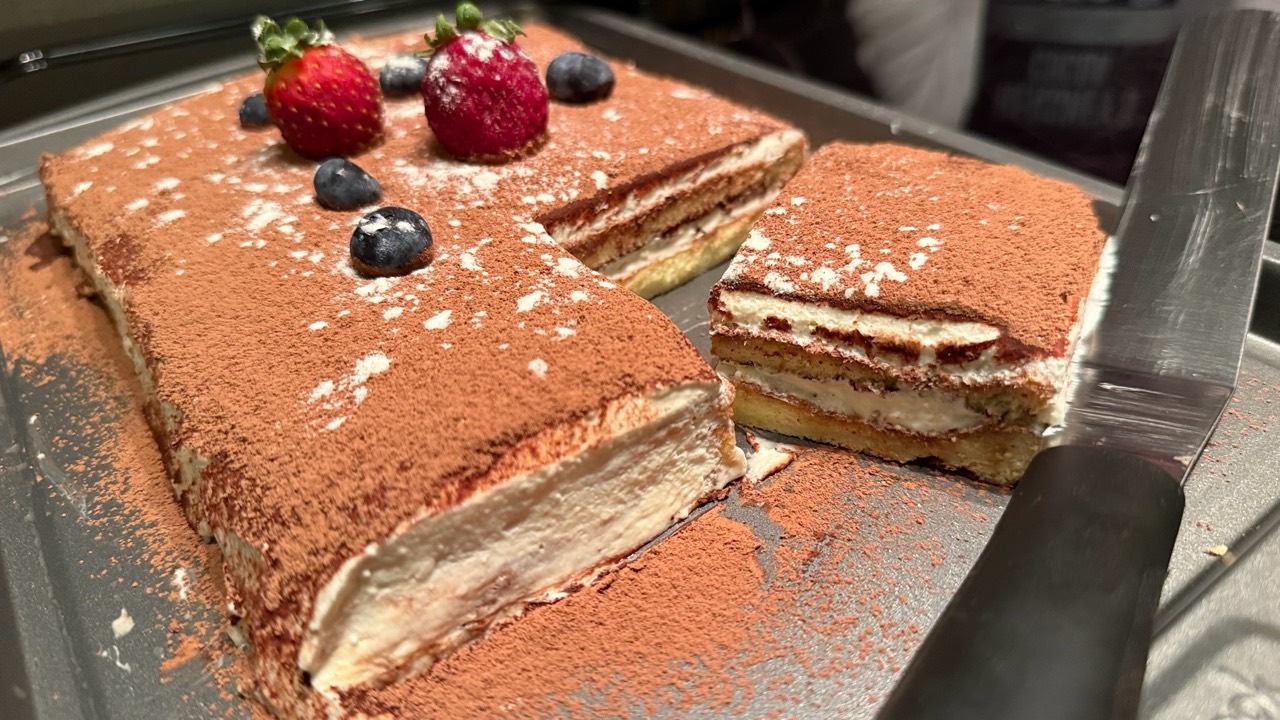 Cocoa-dusted layered dessert topped with strawberries and blueberries